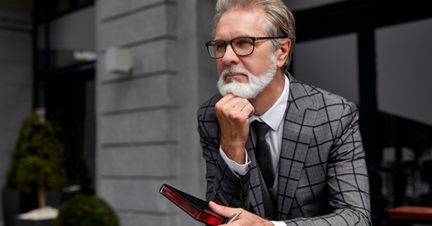 senior business man thinking while holding diary