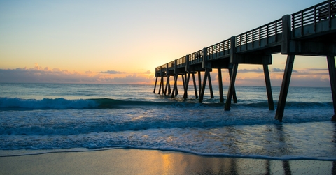vero beach pier at sunset with water at shore