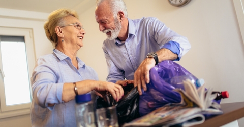 smiling senior couple recycling trash