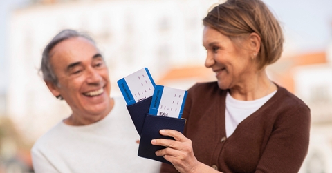 senior tourists holding boarding passes