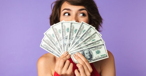 woman covering her face with money
