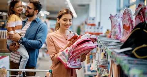 happy mother choosing backpack for daughter