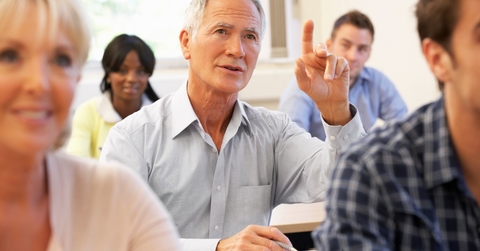 Senior student raising hand in class