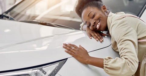 woman hugging car bonnet at showroom