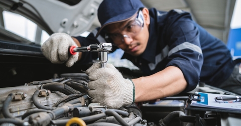 mechanic inspecting car engine at workshop