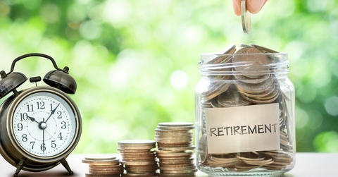hand putting coins in glass jar
