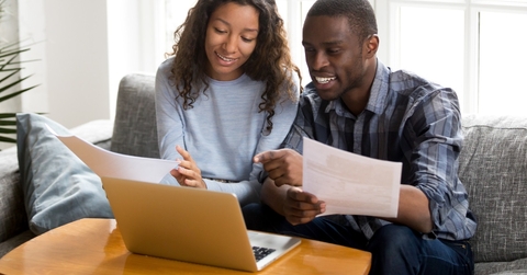 happy african american couple reviewing bills
