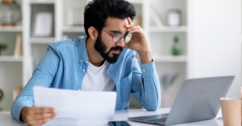 Stressed man working on laptop.