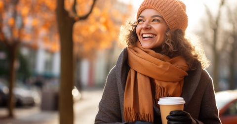Woman relishes a coffee cup on the street.