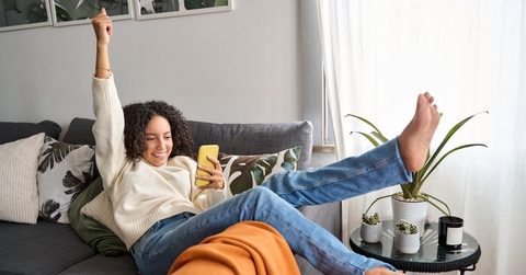 woman relaxing on couch using phone 