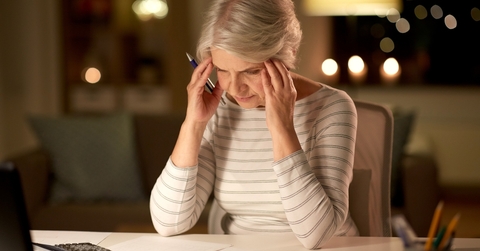 stressed senior woman filling tax form
