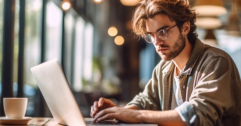 Man working on laptop on a cafe table.