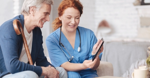 nurse showing tablet to senior patient