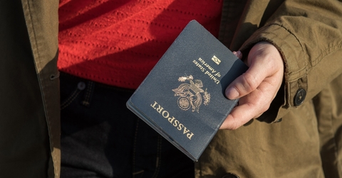 woman wearing coat holding passport