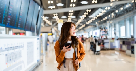 asian woman using mobile at airport