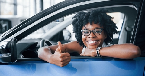 excited african american woman in car