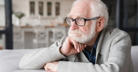 depressed senior man sitting on couch 