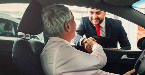 senior man buying car from dealer