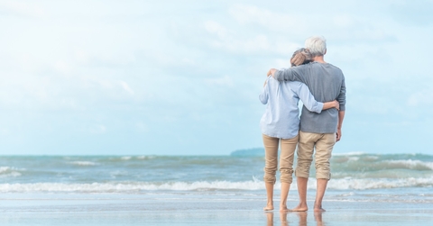 senior couple enjoying beachside waves