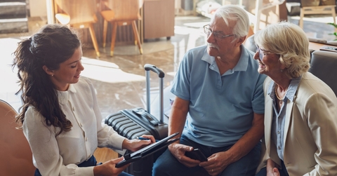 senior couple consulting female travel agent