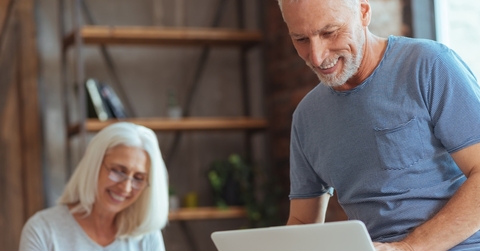 senior couple sorting finances using laptop