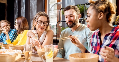 multi ethnic friends eating at restaurant