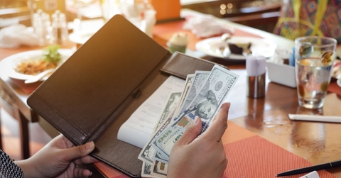 woman keeping tips in bill book