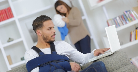 man with arm injury using laptop