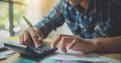 man reviewing bills using calculator