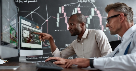 male brokers reviewing stocks together