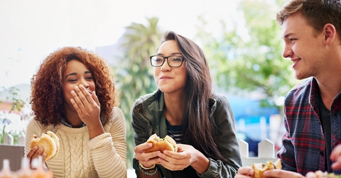  friends eating burgers outdoors