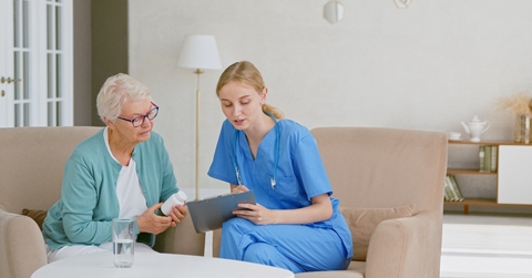nurse prescribing pills to senior woman