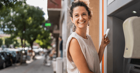 Smiling woman using an ATM