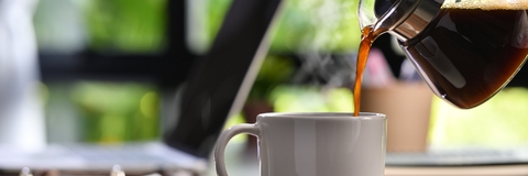 hand pouring steaming coffee