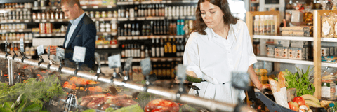 woman looking at vegetables in grocery store