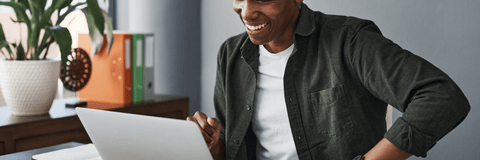 Man smiles while using his laptop. 