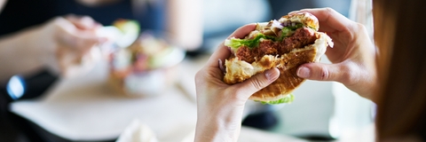 woman eating vegan meatless burger