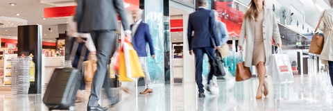 travelers walking in airport concourse