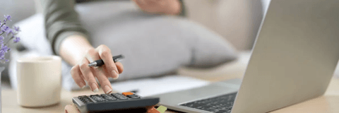 woman calculating bills at laptop