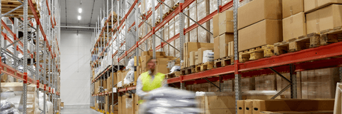 blurred picture of worker carrying loader with goods at warehouse