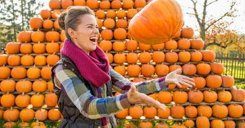 happy woman throwing pumpkin