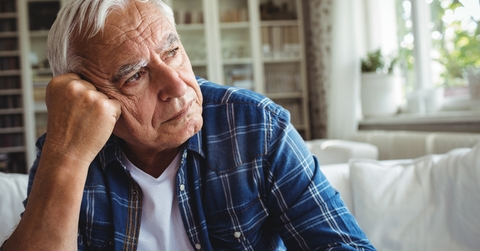 Worried senior man sitting on a sofa