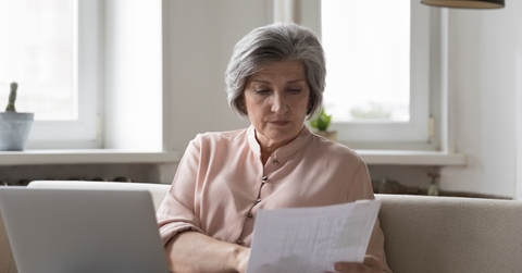 senior female accountant checking paper invoices