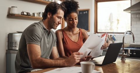 multi ethnic couple reviewing bills together