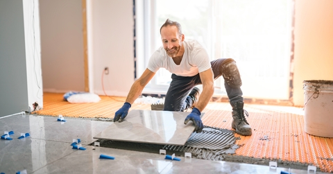 Handyman installing tile on floor