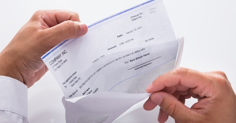 Businessman opening envelope with paycheck