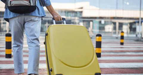 Senior with luggage walking across the street