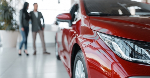 Couple buying new red car