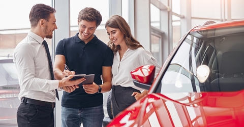 signing papers in card dealership