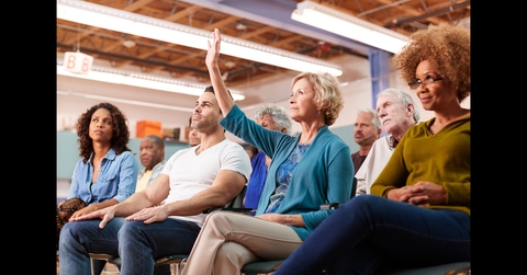 Woman Asking Question At Neighborhood Meeting In Community Center 